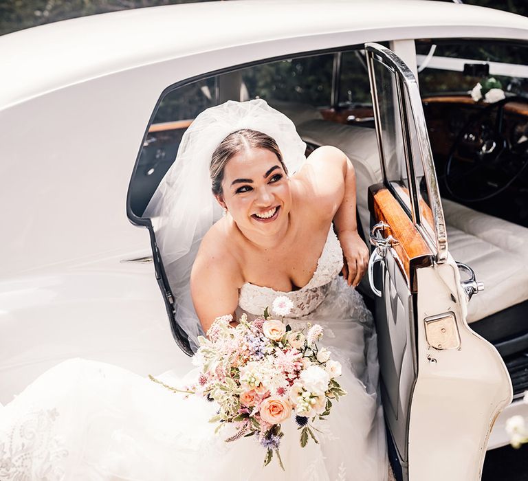 bride-in-princess-wedding-dress-with-veil-in-white-wedding-car