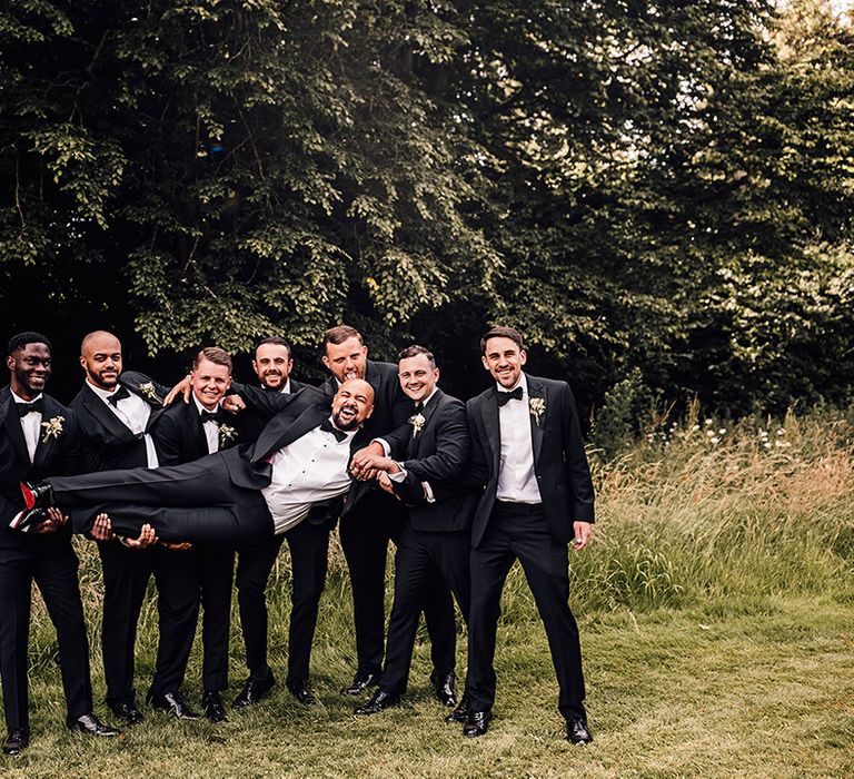 groom-and-groomsmen-in-black-tuxedos-for-wedding