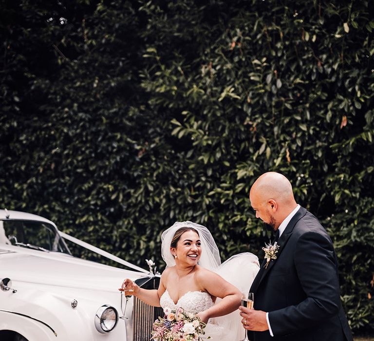 groom-in-black-tuxedo-with-bride-in-strapless-wedding-dress-with-vintage-wedding-car