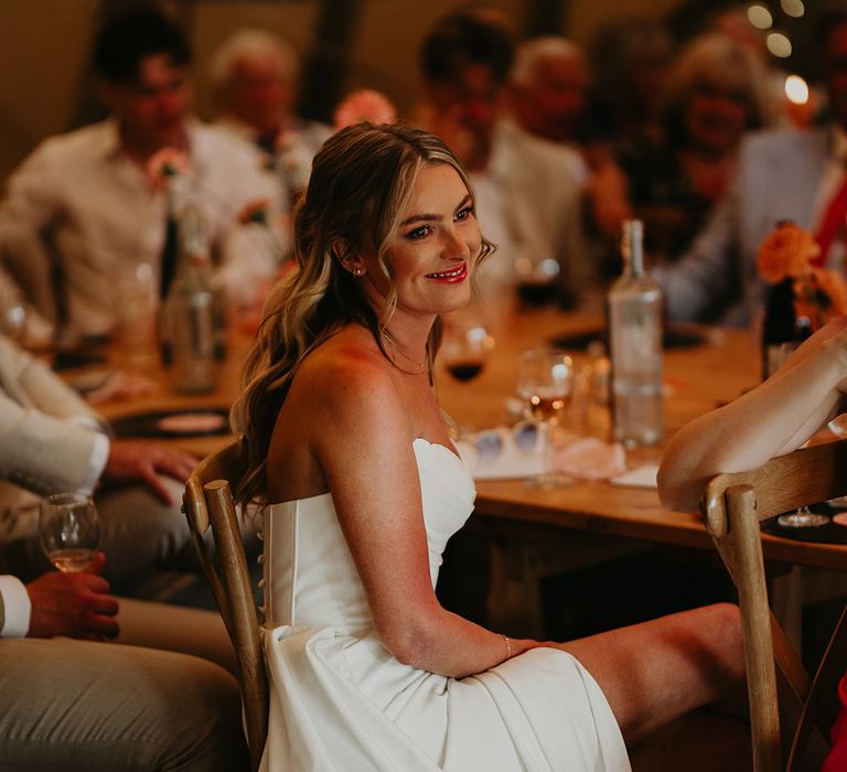 bride-in-strapless-wedding-dress-listening-to-wedding-speeches