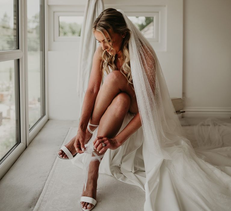 bride-wearing-white-wedding-shoes-with-bridal-veil