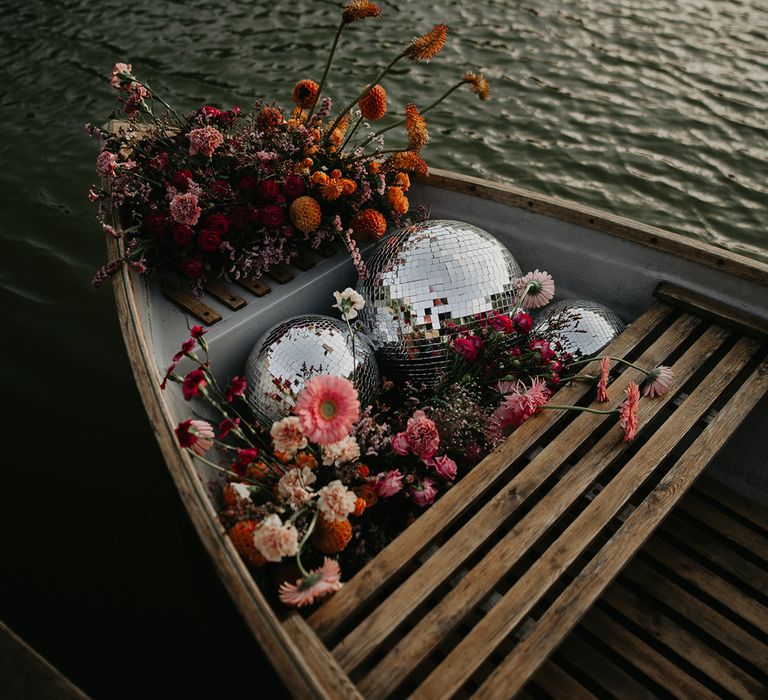 large-disco-balls-and-pink-flowers-in-row-boat