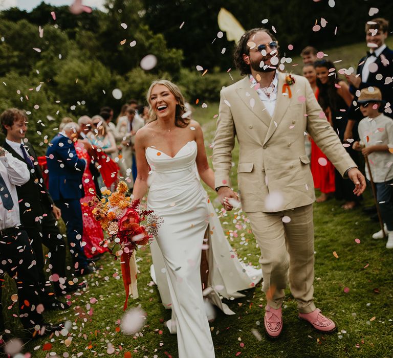 strapless-wedding-dress-with-groom-in-beige-suit-having-confetti-moment