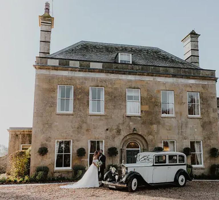 cuckney house nottinghamshire wedding venue, building exterior with couple standing outside and wedding car