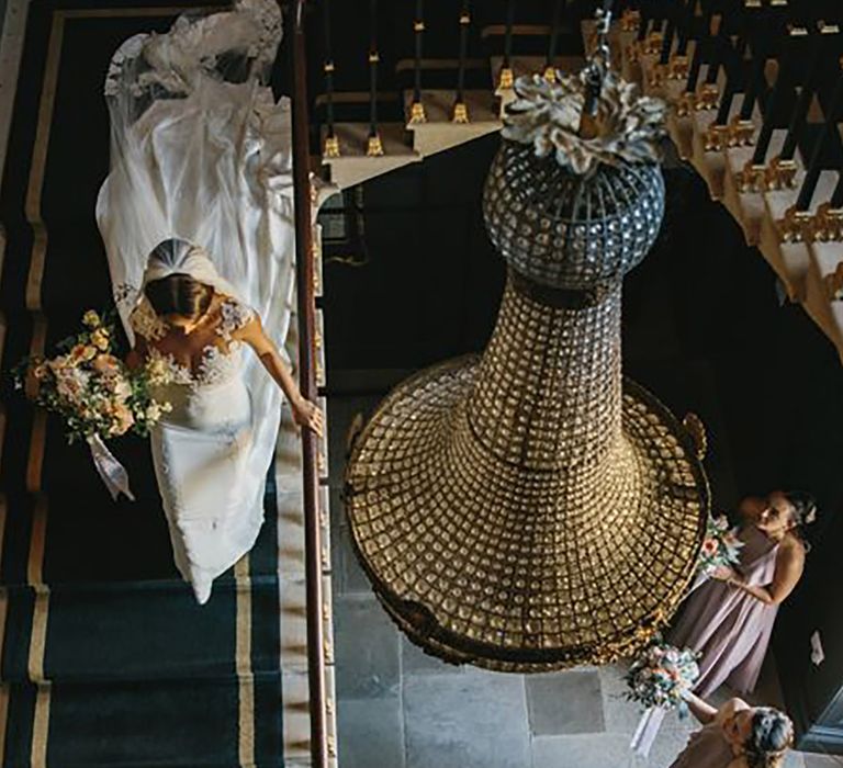 stubton hall wedding venue in nottinghamshire, bride coming down the stairs to her bridesmaids 