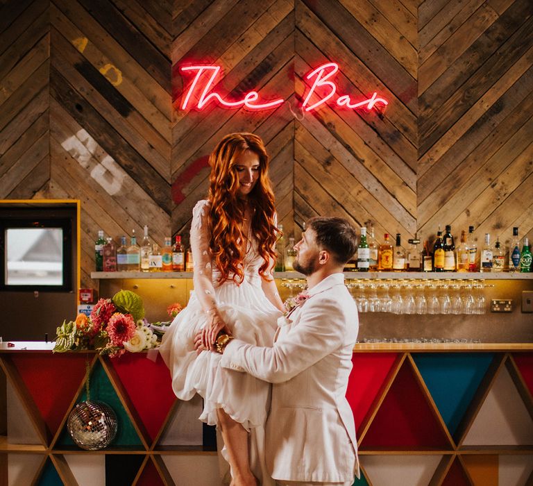 bride-sitting-on-wedding-bar-design-with-groom