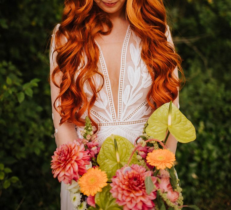 bride-wearing-curled-hairstyle-with-lace-wedding-dress-and-pink-wedding-bouquet