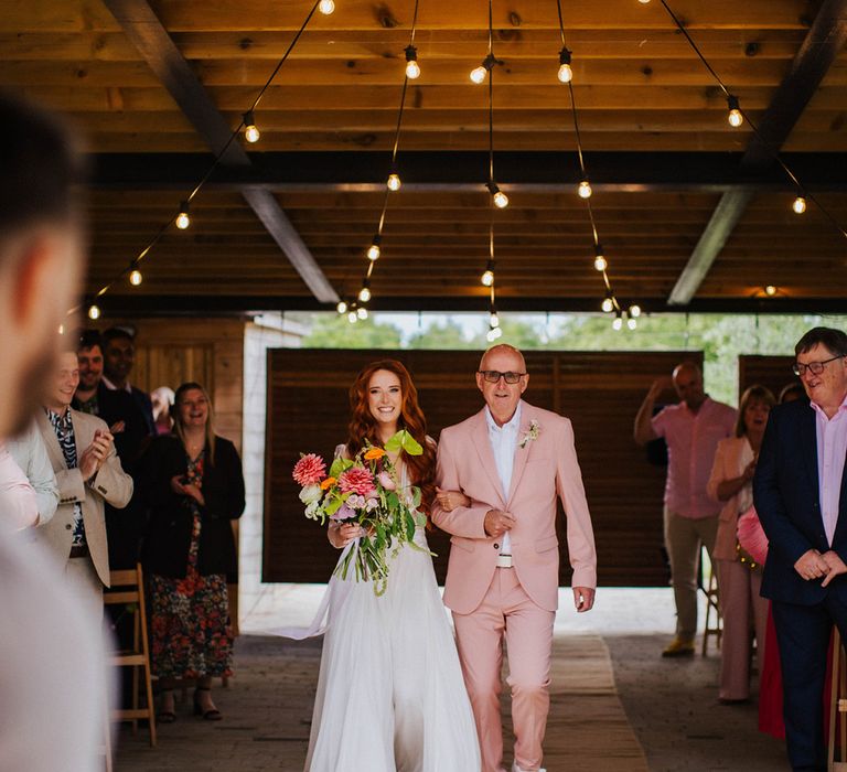 father-of-the-bride-in-pink-suits-walking-bride-down-the-aisle