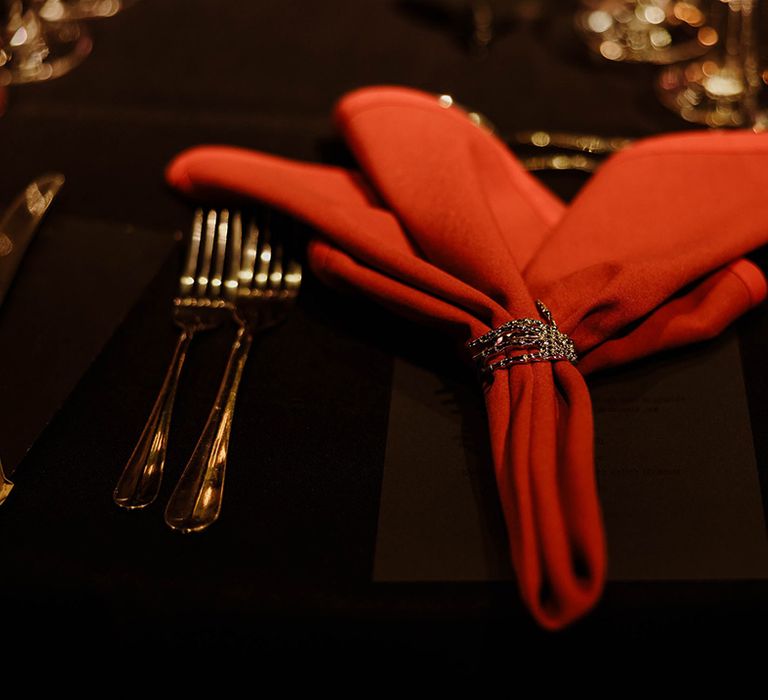 gold-cutlery-and-red-napkins-with-napkin-rings