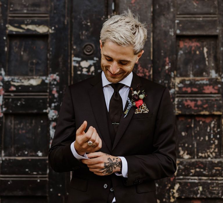 groom-in-all-black-wedding-suit-with-rose-buttonhole