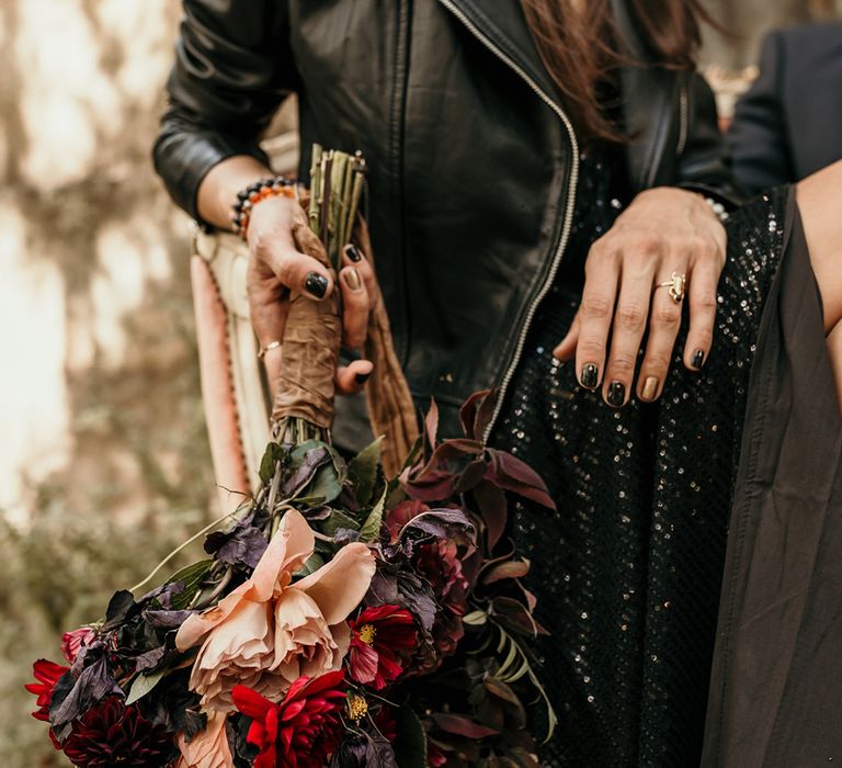 bride-in-black-sequin-dress-and-leather-jacket-with-bouquet