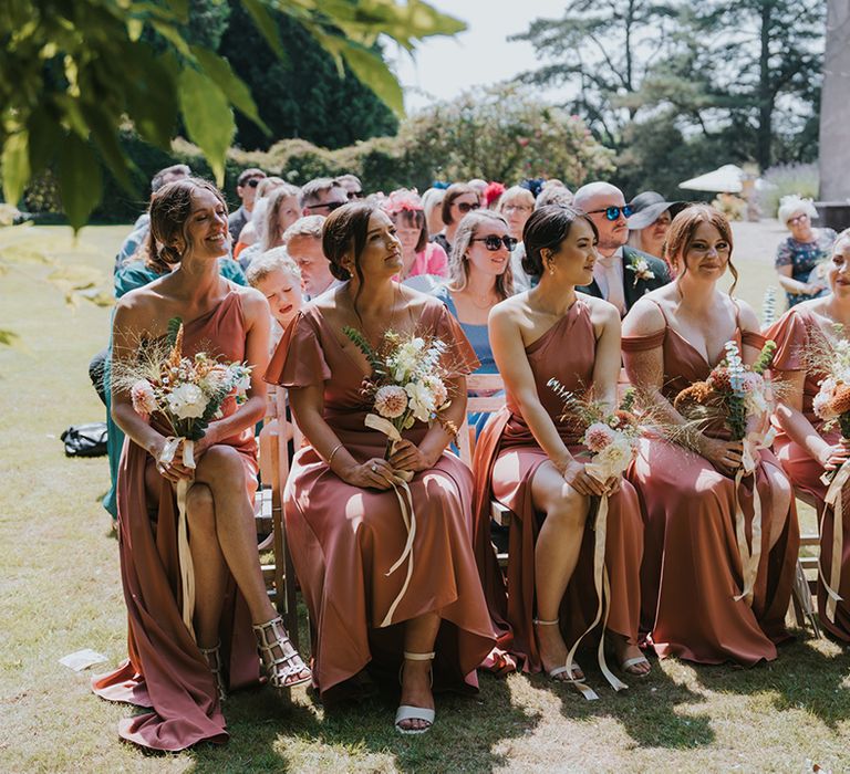 bridal-party-wearing-peach-bridesmaid-dresses-with-bouquets