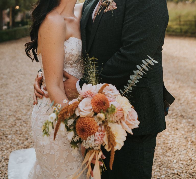 bride-holding-bouquet-smiling-up-at-groom-with-pink-wedding-bouquet