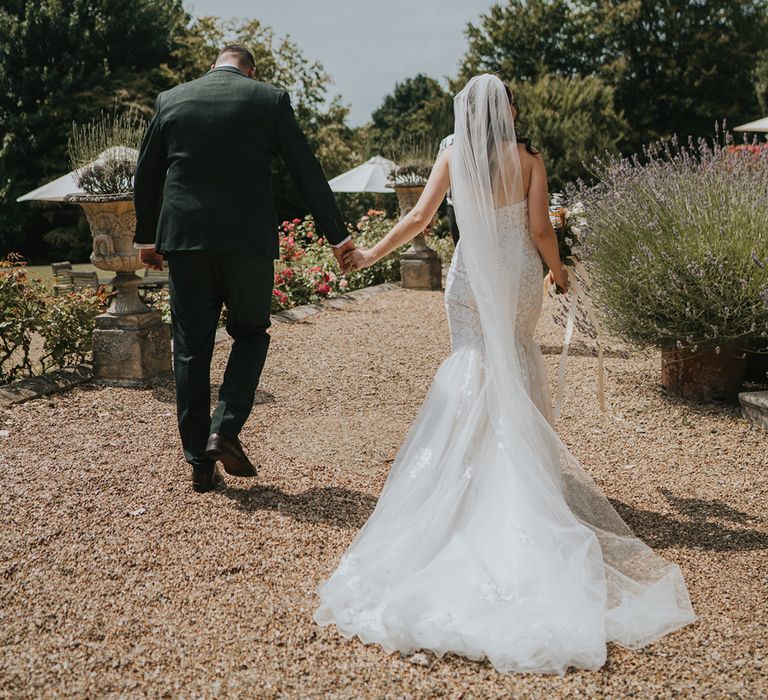 bride-in-mermaid-wedding-dress-walking-with-groom