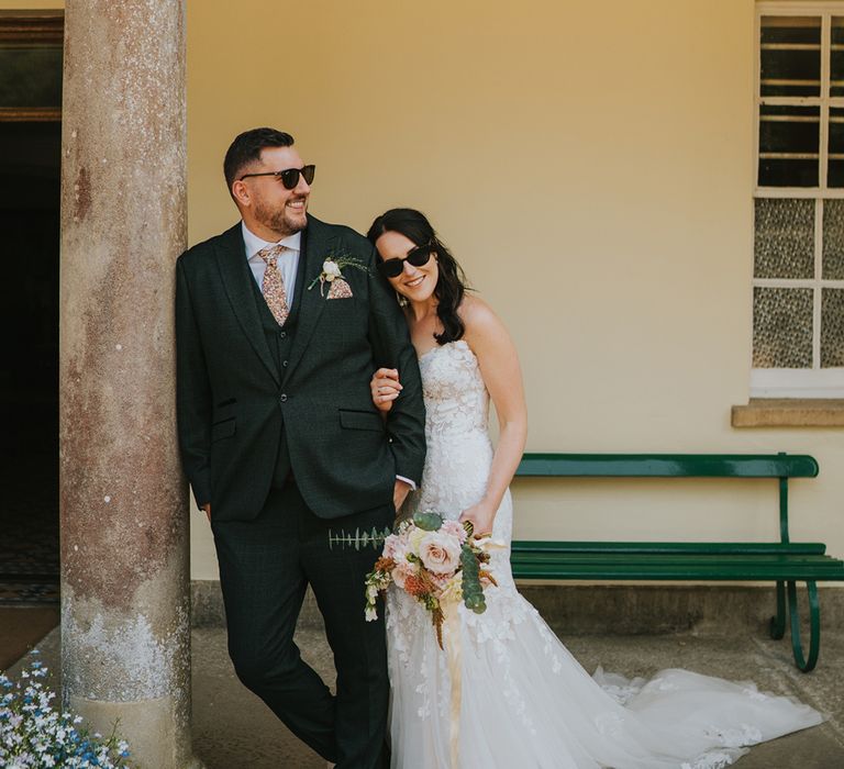 bride-in-mermaid-wedding-dress-with-groom-in-green-wedding-suit-and-sunglasses