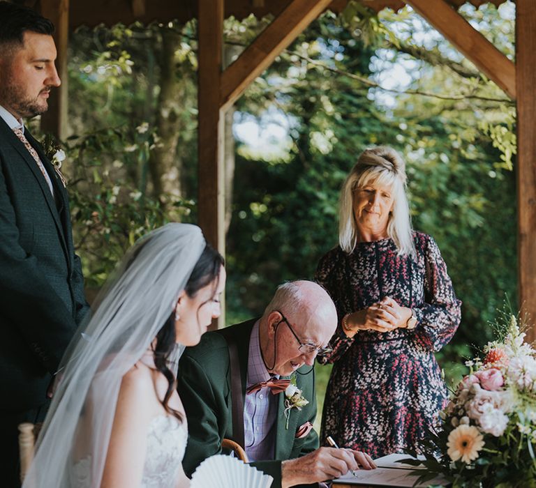 grandad-signs-wedding-register-at-outdoor-wedding