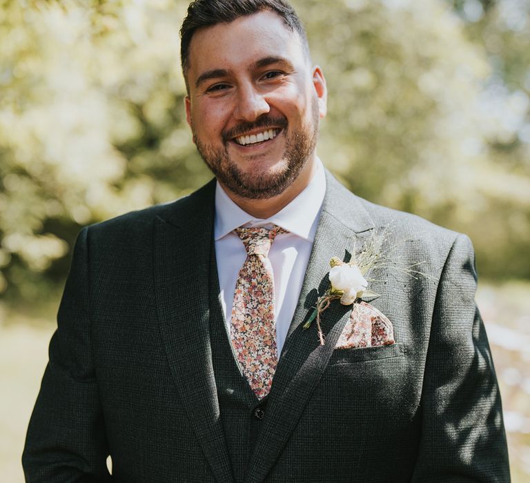 groom-in-green-three-piece-wedding-suit-with-flower-tie