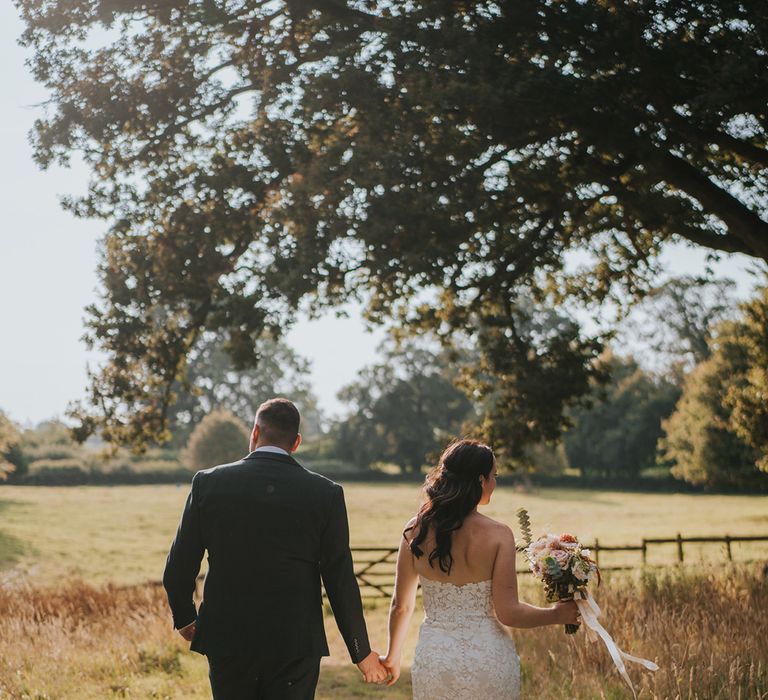 mermaid-wedding-dress-with-green-wedding-suit-at-outdoor-wedding