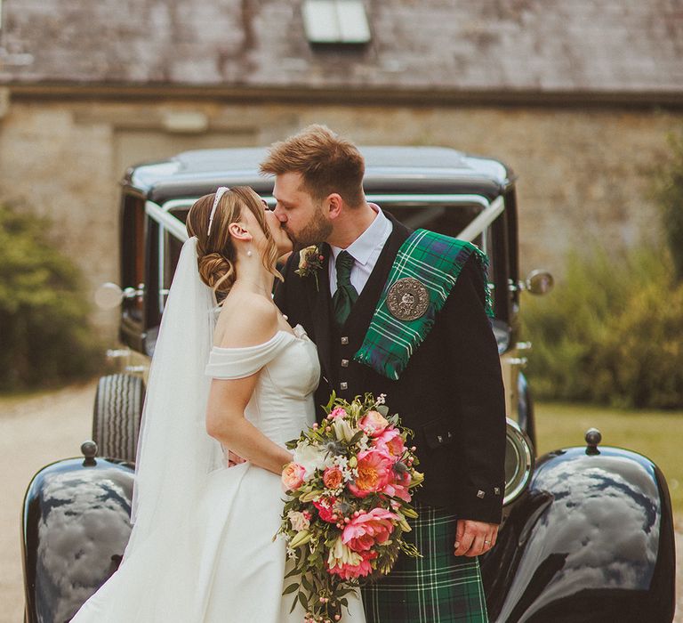 groom-in-green-kilt-kissing-bride-in-princess-wedding-dress