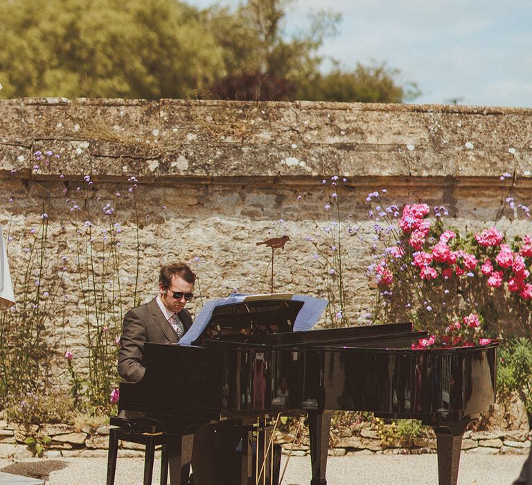 pianist-plays-baby-gand-piano-at-outdoor-wedding-ceremony