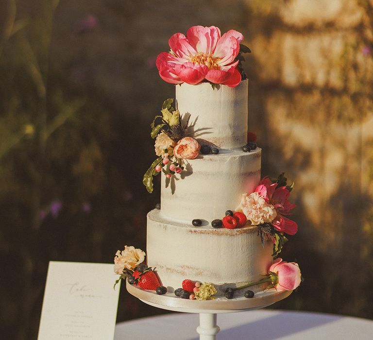 three-tier-white-iced-wedding-cake-wtith-pink-flower-decorations