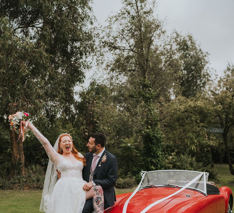 bride-and-groom-with-red-wedding-car-transport.