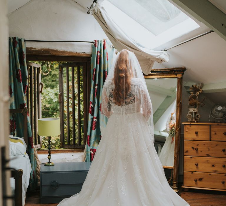 bride-in-lace-wedding-dress-looking-in-mirror