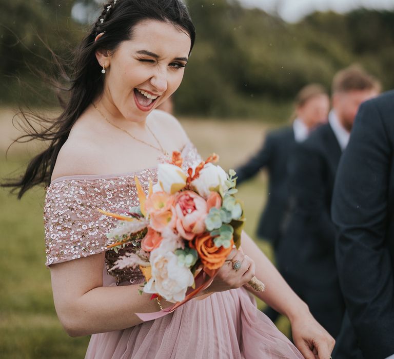 bridesmaid-winking-at-camera-with-pink-sequin-bridesmaid-dresses