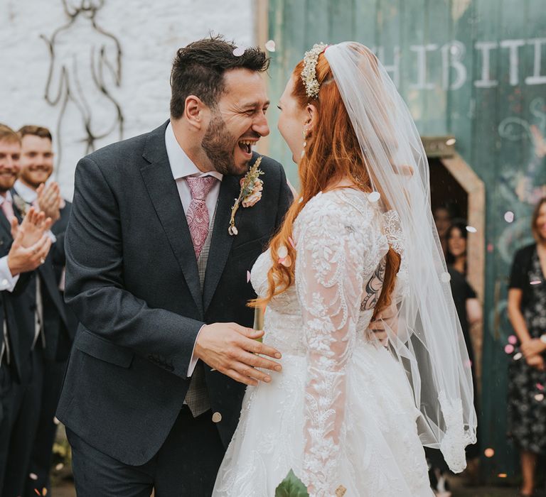 groom-smiles-at-bride-at-barn-wedding