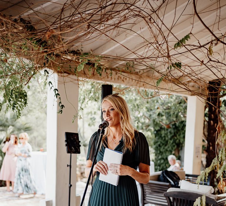 best-woman-reads-wedding-speech-in-dark-green-pleated-bridesmaid-dress