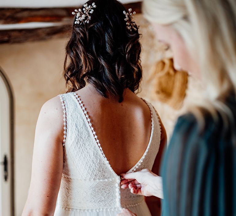 bride-gets-into-her-wedding-dress-with-short-curled-hair