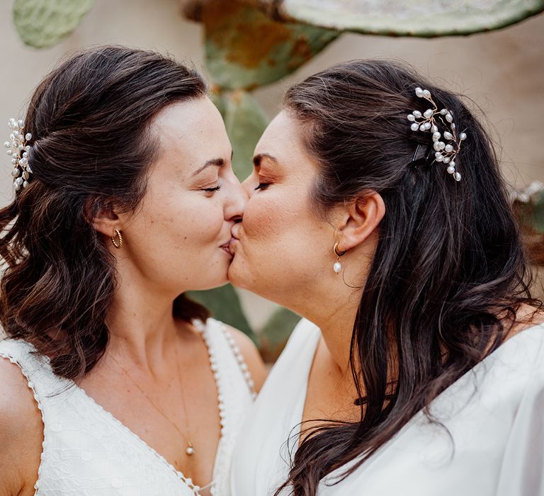 kissing-brides-wearing-brown-hair-in-half-up-half-down-hairstyles-with-floral-accessory