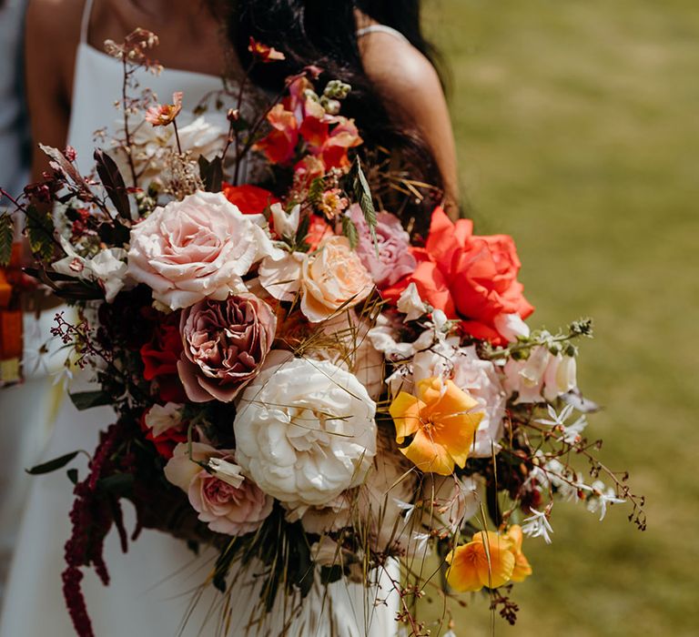 bride-carrying-rose-wedding-bouquet-with-red-and-yellow-flowers