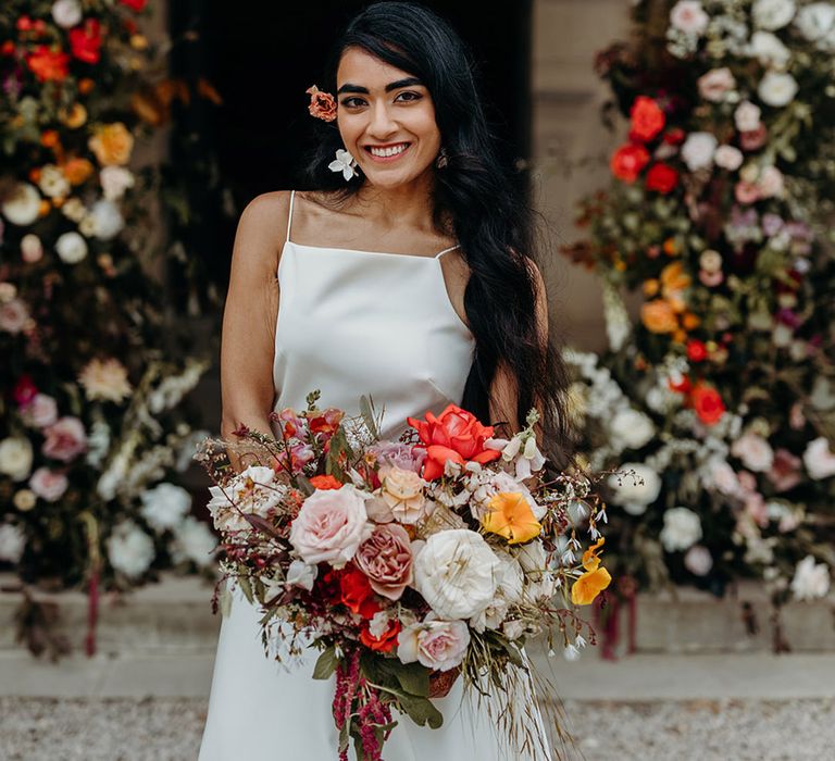 bride-holding-red-and-yellow-rose-wedding-bouquet