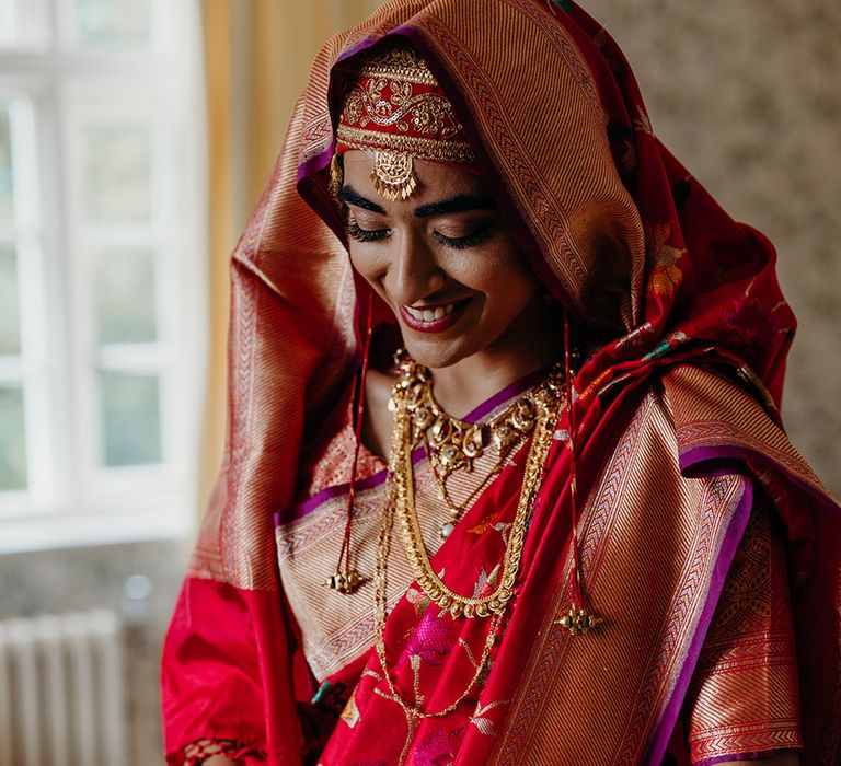 bride-wearing-traditional-red-wedding-outfit-for-hindu-wedding-with-gold-jewellery-and-bangles