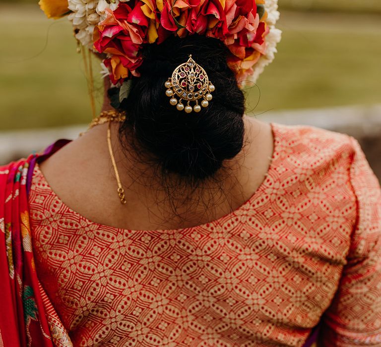 bride-with-low-bun-updo-with-flowers-and-gold-charm-decoration