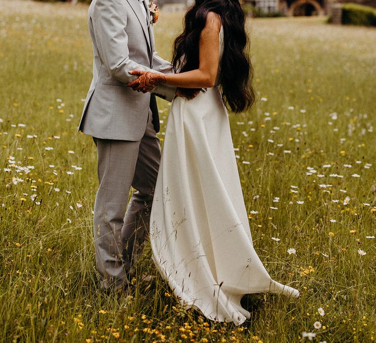 groom-wearing-light-grey-wedding-suit-embracing-bride-for-wedding-photo