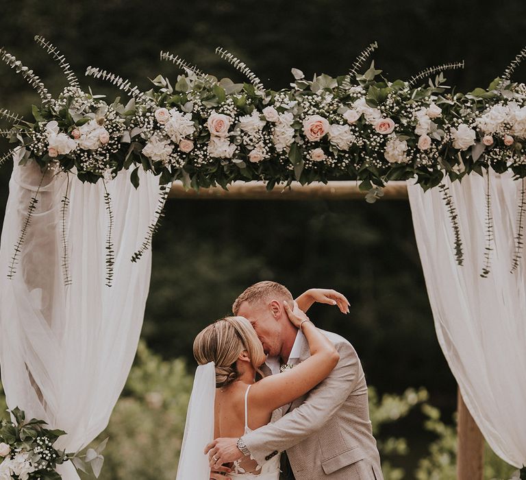 bride-and-groom-kiss-at-chateau-wedding-outdoor-ceremony