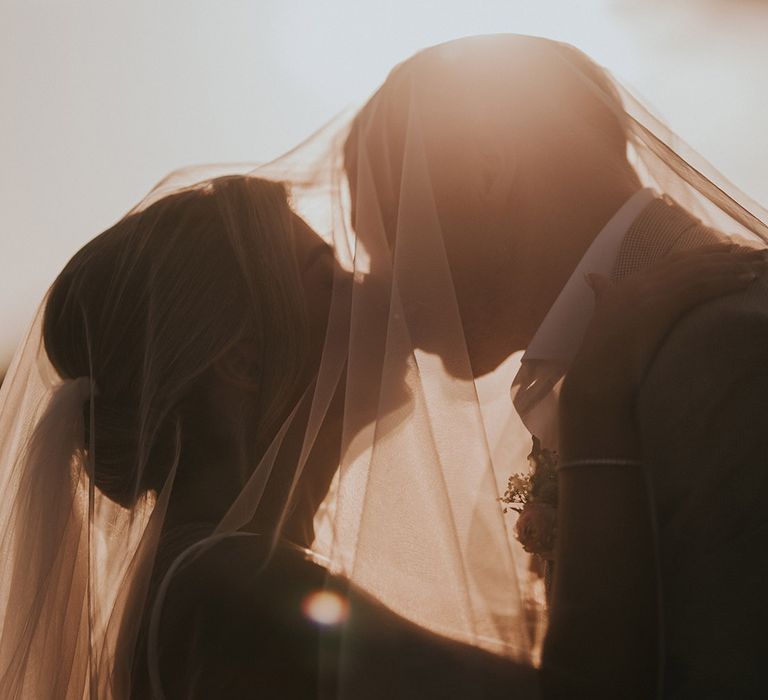 bride-and-groom-kissing-under-bride-wedding-veil