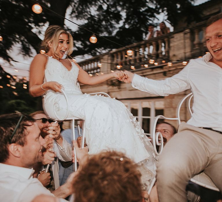 bride-and-groom-on-chairs-at-wedding-party