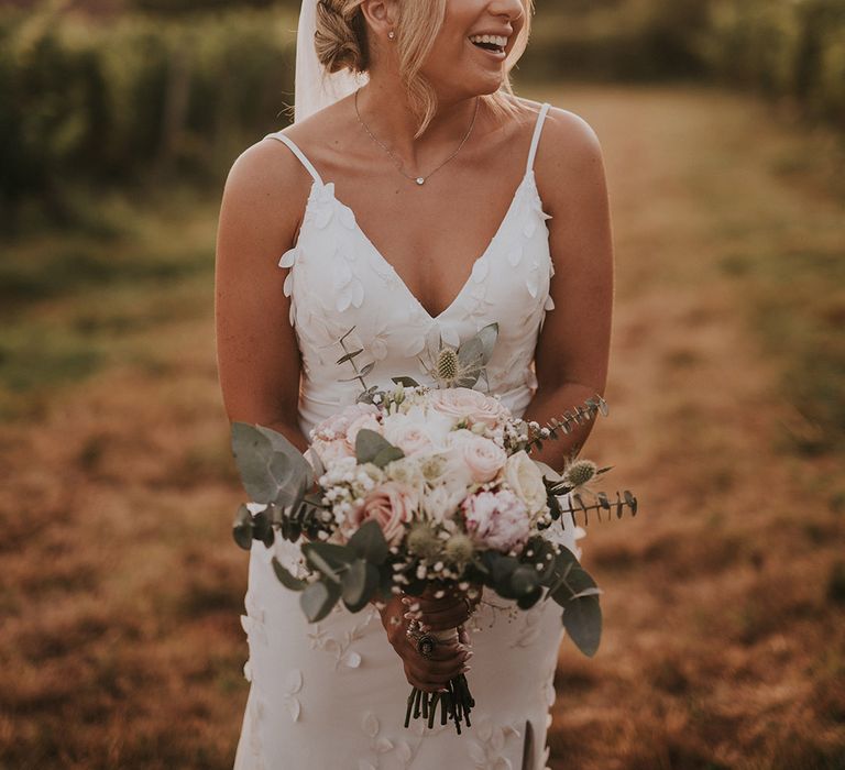 bride-in-flower-wedding-dress-with-white-wedding-bouquet-and-blonde-updo