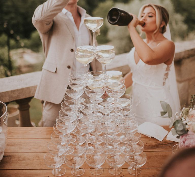 champagne-tower-with-bride-and-groom-drinking-champagne-from-bottle