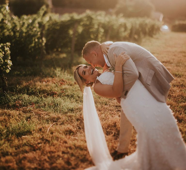 golden-hour-kiss-photo-of-groom-embracing-bride