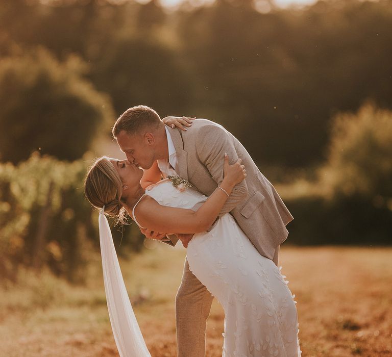 golden-hour-photo-of-groom-kissing-bride-in-romantic-kiss