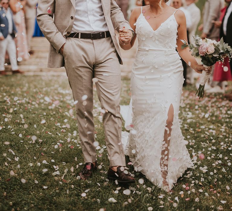 groom-in-beige-wedding-suit-with-bride-in-flower-wedding-dress