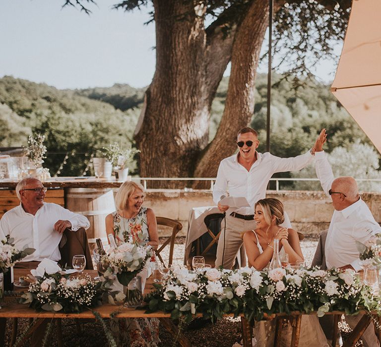 groom-stands-reading-wedding-speech-at-outdoor-destination-wedding-in-france