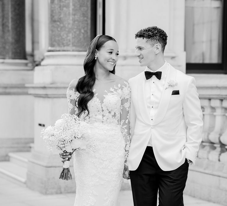 bride-in-long-sleeve-lace-wedding-dress-with-groom-in-white-tuxedo