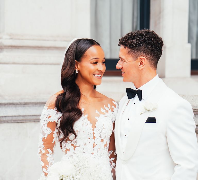 bride-wearing-illusion-lace-wedding-dress-with-long-sleeves-smiling-at-groom