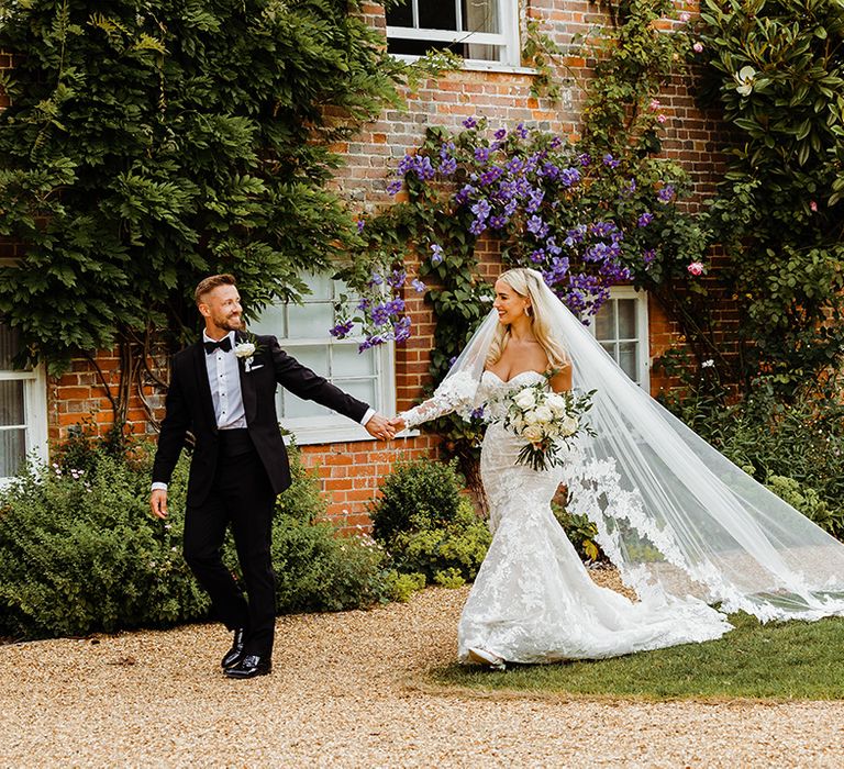 bride-in-lace-wedding-dress-with-groom-in-black-tuxedo