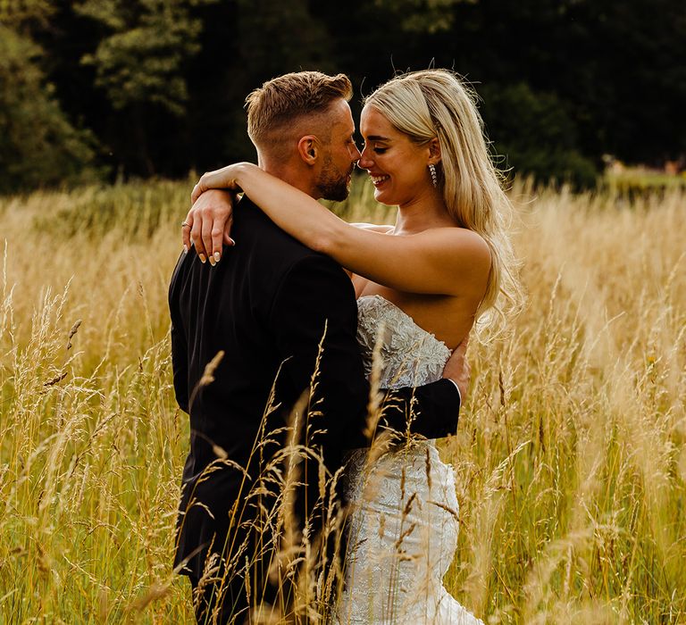 bride-in-strapless-lace-wedding-dress-embracing-groom